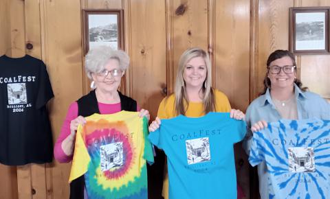 Brilliant CoalFest T-shirts are in stock. Get yours now to wear to the festival or pick one up on Friday and Saturday, May 24-25 at the 23rd annual event. Shown displaying a few examples are (from left) town water clerk Ann Davis, town clerk Jessica Lee and town water clerk Brittany Reid. The t-shirts vary in cost according to size and color from $10 to $20. Besides those shown, other colors include black, gray and pink.