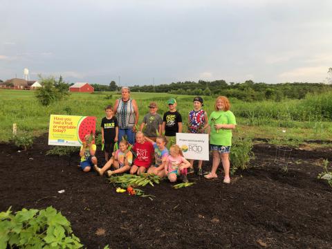 SNAP-Ed Extension Agent Ginger Eatman is shown with students at a garden harvest at the Hackleburg High School and Hackleburg Elementary School garden. See column on page 4 and photo page on 12.