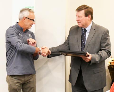 Phil Segraves, right, shakes hands with incoming mayor Bobby Bellew during Segraves' reception for his dedication as mayor of Guin.