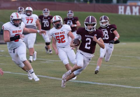 Aggie Mason Holloway (#2) runs from defenders. Also shown is Blake Vaughn (#28), Jaxon Ledbetter (#64) and Jackson Emerson (#70).