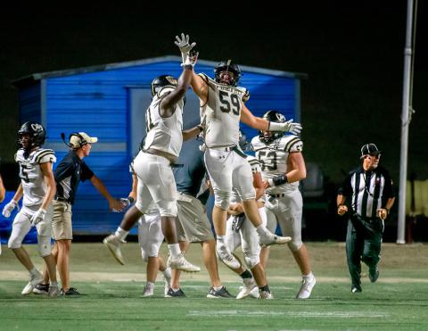 Miles Miles (#59) congratulates a teammate with a high five.