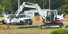 Work crews are pictured excavating the land near the Hamilton walking track in order to lay pipe supplying water to the new Hamilton Middle School gym facility.