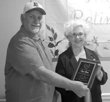 Brilliant Mayor Perry Franks presents town water clerk Ann Davis with a plaque recognizing her 25 years of service on May 9 at Cedar Landing with Brilliant council members, town employees and other guests in attendance during a retirement celebration held in her honor.